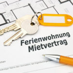 Mietvertrag für Ferienwohnung mit Schlüssel und Kugelschreiber