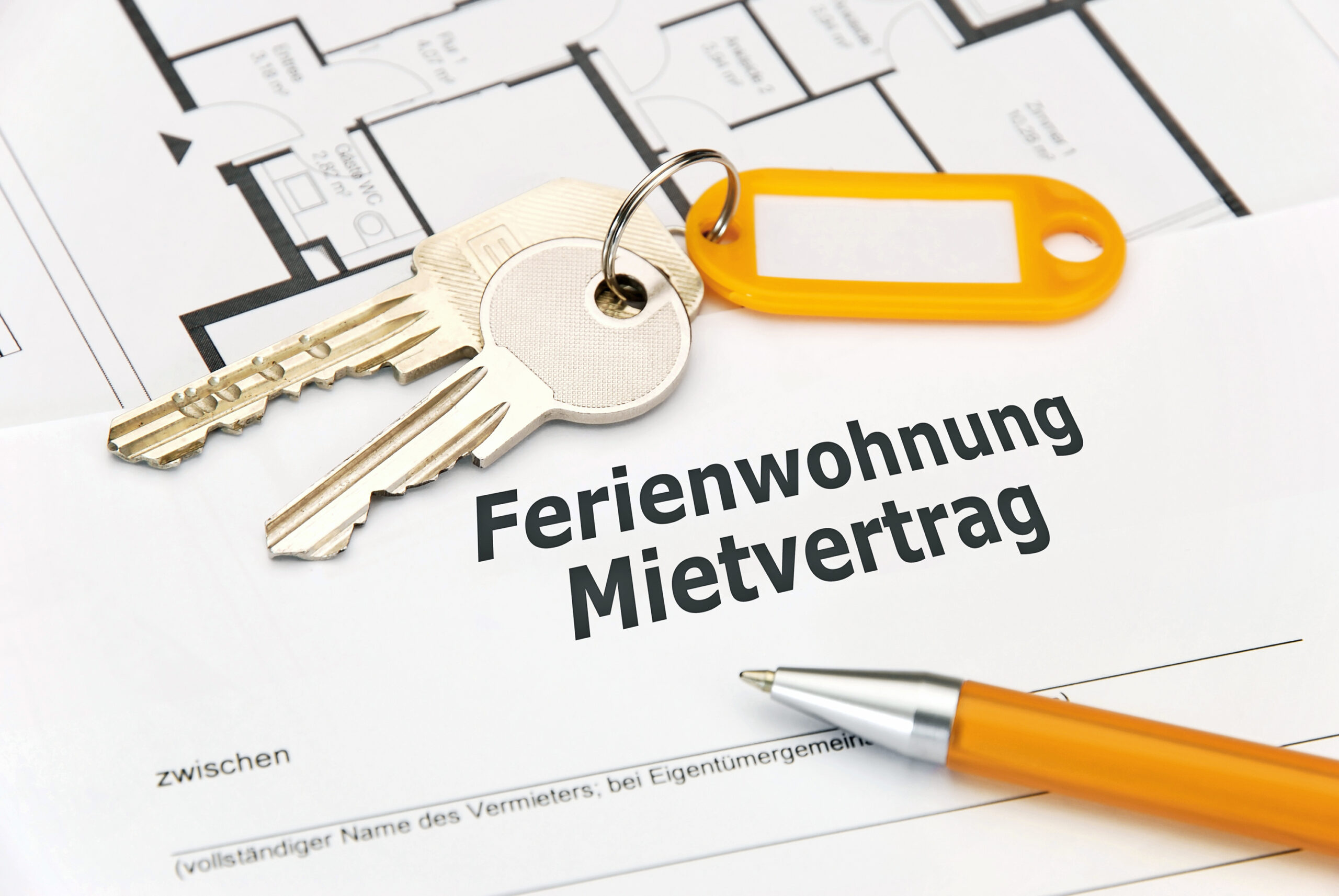 Mietvertrag für Ferienwohnung mit Schlüssel und Kugelschreiber