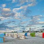 Strandkörbe am Strand von Warnemünde - Warnemünder Teepott und Leuchtturm im Hintergrund